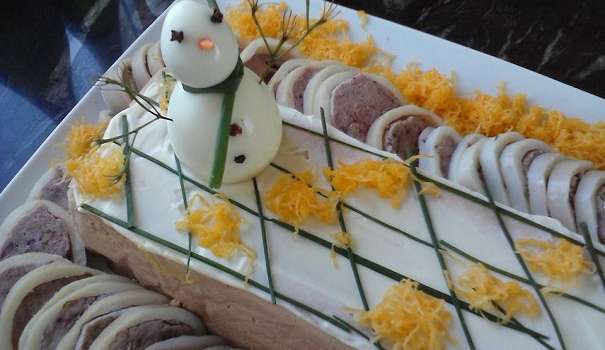 Un adorno invernal, con huevo duro normal y de codorniz, clavos de olor, zanahoria y una tira de cebollino.